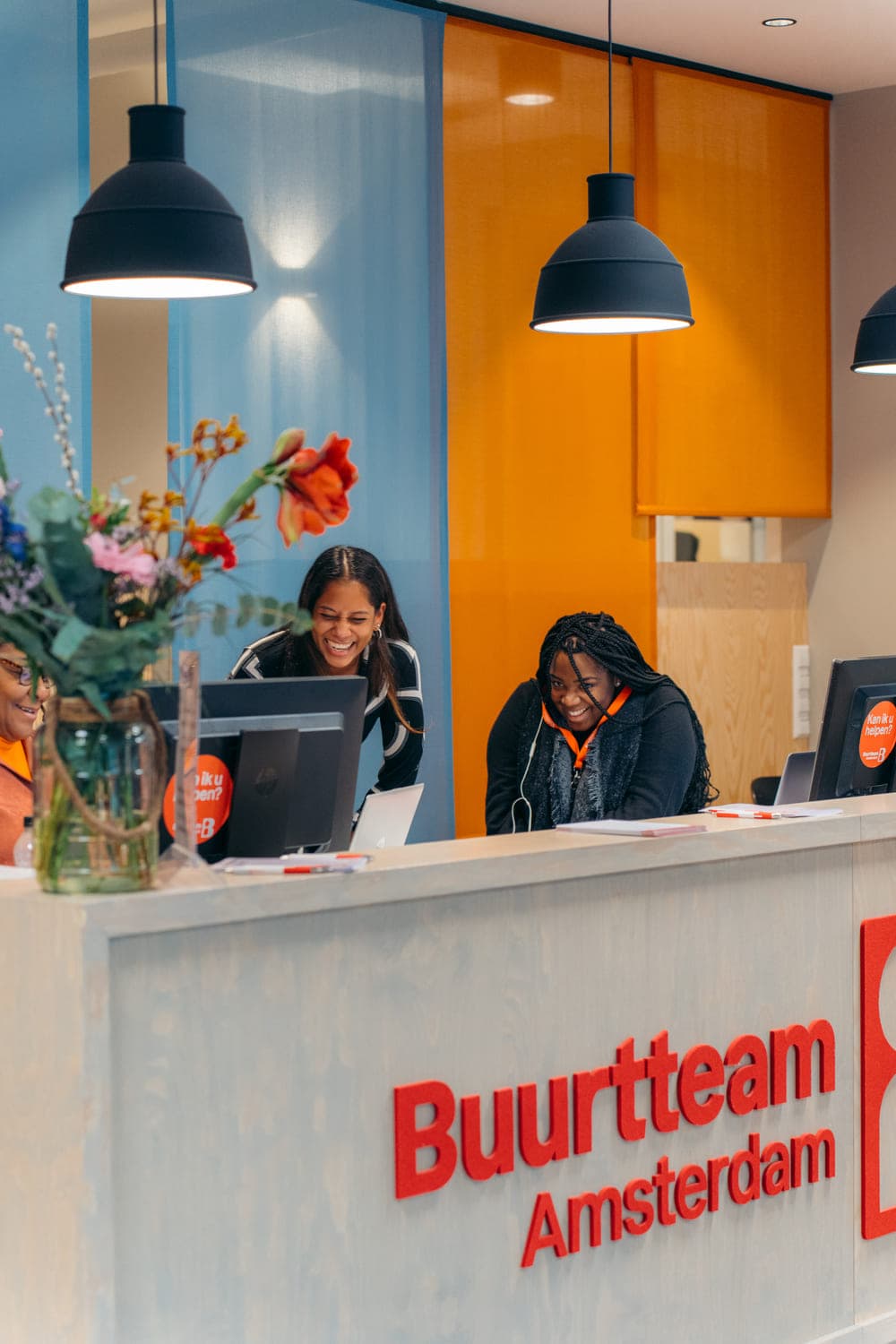 Receptiebalie van Buurtteam Amsterdam met twee medewerkers